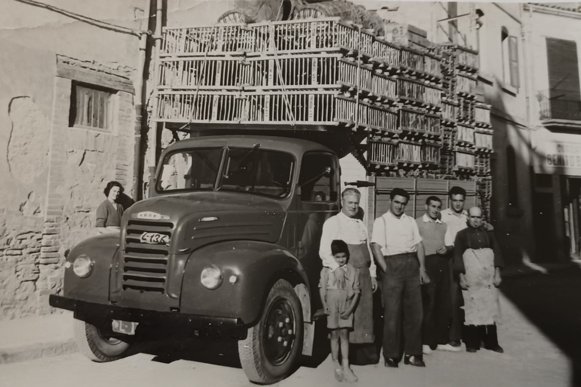 Fotografia històrica de la família Gassó amb el camió de transport d’aviram, símbol dels primers anys de trajectòria.