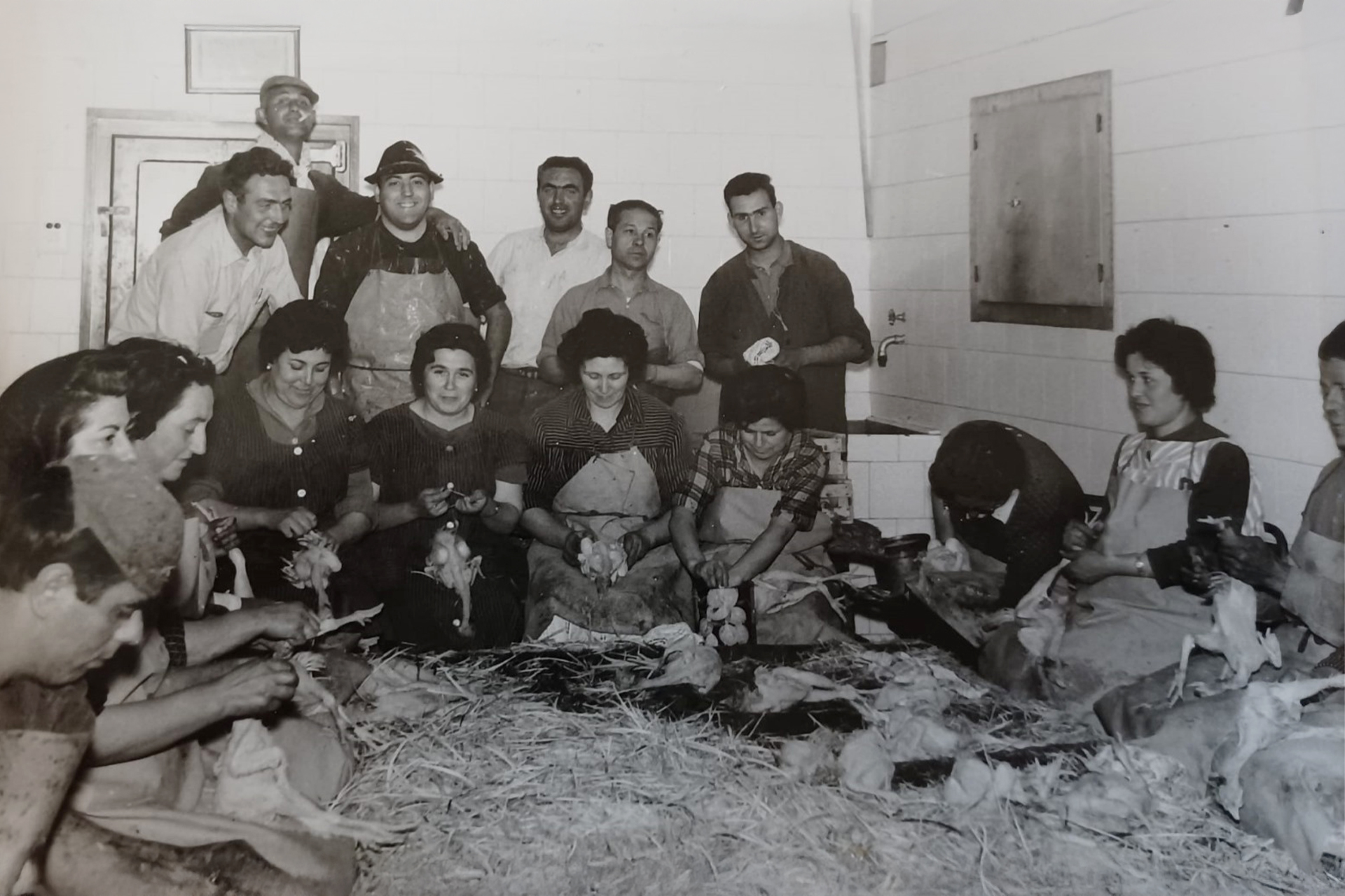 Fotografia històrica de treballadors i treballadores de Pere Gassó en el procés manual d’aviram.